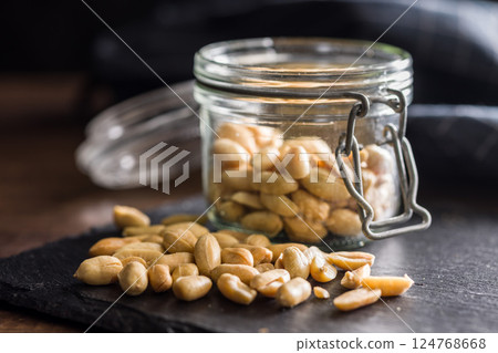 Roasted salted peanuts in jar on wooden table. Roasted salted peanuts in jar on wooden table. 124768668