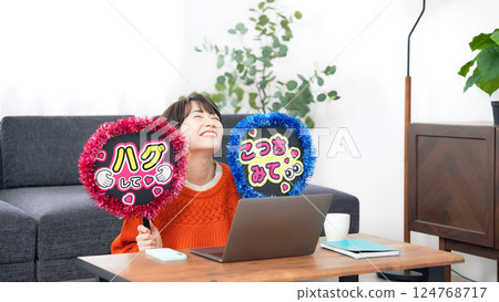 A middle-aged woman watching a live broadcast and promoting her favorite idol A middle-aged woman watching a live broadcast and promoting her favorite idol 124768717