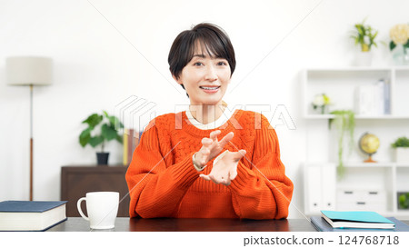 Middle-aged woman in casual wear talking while looking at the camera Middle-aged woman in casual wear talking while looking at the camera 124768718