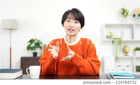 穿著休閒服的中年婦女一邊看著鏡頭一邊說話 穿著休閒服的中年婦女一邊看著鏡頭一邊說話 124768732