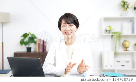 一名身穿白大褂的中年婦女對著鏡頭說話 124768739