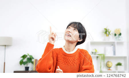 A middle-aged woman talking while looking up in a room 124768742