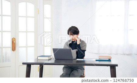 在辦公桌上使用筆記型電腦工作的女性 在辦公桌上使用筆記型電腦工作的女性 124768750