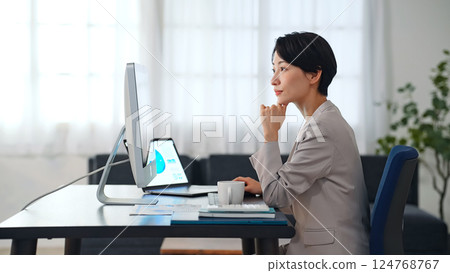 A female business person working on a computer in a dark office 124768767
