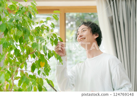 Man taking care of houseplants 124769148