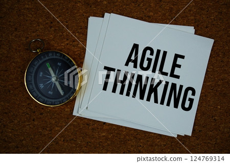 Agile Thinking text on paper card with compass on cork paper background 124769314