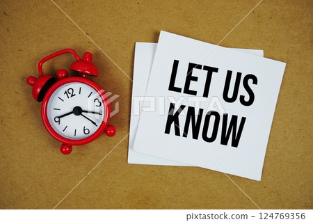 Let Us Know text on sticky note with alarm clock on paper craft background Let Us Know text on sticky note with alarm clock on paper craft background 124769356