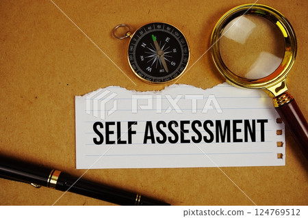 Self Assessment text on paper torn with compass and magnifying glass on paper craft background Self Assessment text on paper torn with compass and magnifying glass on paper craft background 124769512