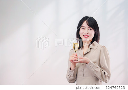 微笑的年輕女子喝氣泡酒(簡單的背景) 微笑的年輕女子喝氣泡酒(簡單的背景) 124769523