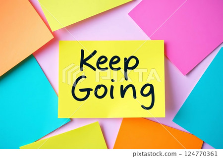 Text Keep going on yellow sticky note with colorful notes 124770361