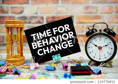 Time For Behavior Change text on paper card with alarm clock and stationary on wooden background 124770652