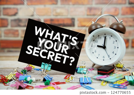 What's Your Secret? text on paper card with alarm clock and stationary on wooden background What's Your Secret? text on paper card with alarm clock and stationary on wooden background 124770655