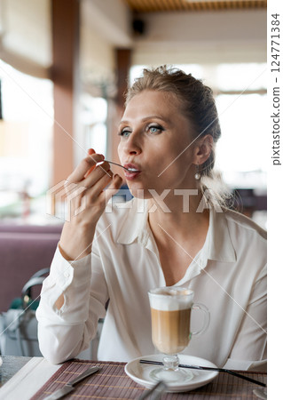 A woman is eating a meal at a restaurant 124771384