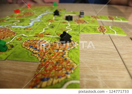 Mozyr, Belarus, April 03 2024: A board game carcassonne black meeple stands on a tile with the city. Rules for building and closing cities Mozyr, Belarus, April 03 2024: A board game carcassonne black meeple stands on a tile with the city. Rules for building and closing cities 124771733