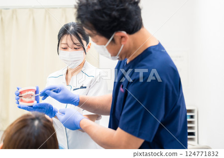 牙醫使用牙齒模型解釋牙科治療 牙醫使用牙齒模型解釋牙科治療 124771832
