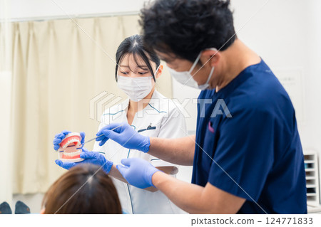 牙醫使用牙齒模型解釋牙科治療 牙醫使用牙齒模型解釋牙科治療 124771833