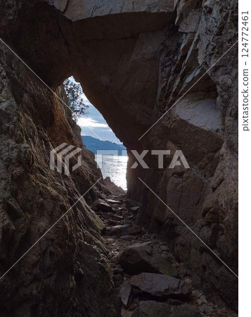 Mysterious seascape peeking through the gaps in the rocks 124772461