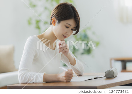 一名 30 多歲女性在客廳學習 一名 30 多歲女性在客廳學習 124773481