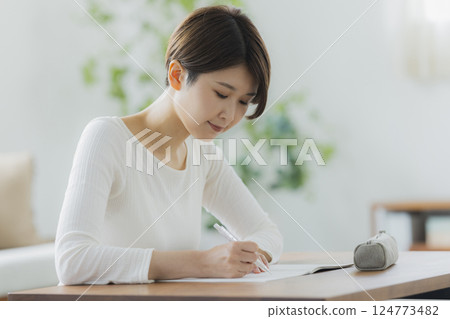 一名 30 多歲女性在客廳學習 一名 30 多歲女性在客廳學習 124773482