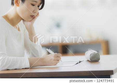 一名 30 多歲女性在客廳學習 124773491