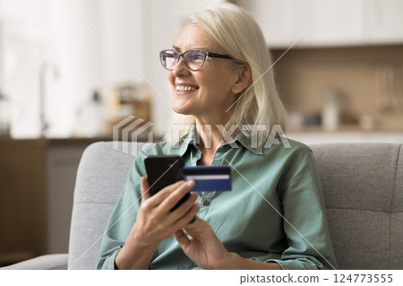 Happy mature lady enjoy online shopping using smartphone credit card 124773555