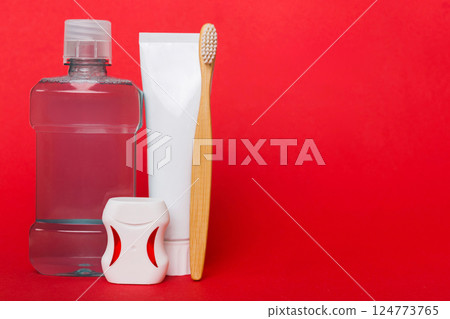 Mouthwash and other oral hygiene products on colored table top view with copy space. Flat lay. Dental hygiene. Oral care products and space for text on light background. concept 124773765