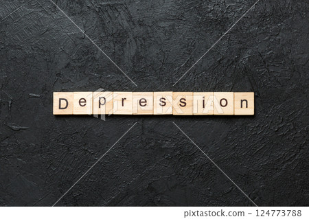 Depression word written on wood block. Depression text on table, concept 124773788