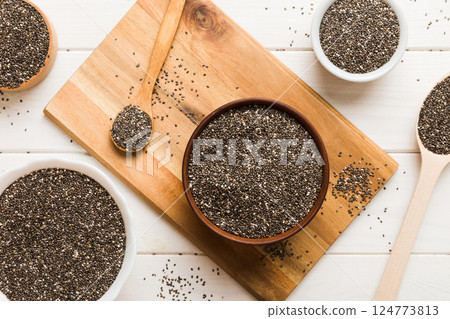 Chia seeds in bowl and spoon on colored background. Healthy Salvia hispanica in small bowl. Healthy superfood Chia seeds in bowl and spoon on colored background. Healthy Salvia hispanica in small bowl. Healthy superfood 124773813