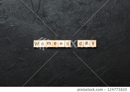 Womans day word written on wood block. Womans day text on cement table for your desing, concept 124773820