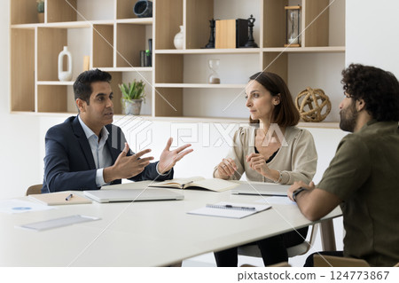 Board of directors gathered at conference table, engaged in negotiations Board of directors gathered at conference table, engaged in negotiations 124773867
