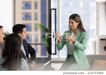 Excited Latin business leader woman holding brainstorming meeting 124773868
