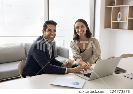 Business professionals, man and woman sitting at table in office 124773878