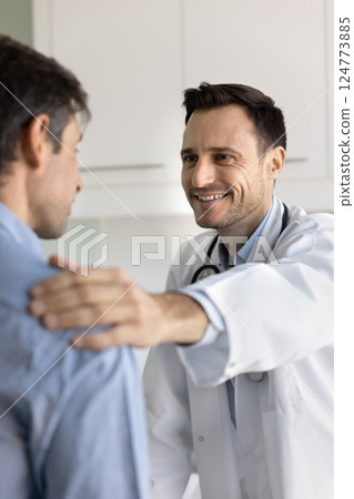 Physician in white coat speaking with sad male patient 124773885