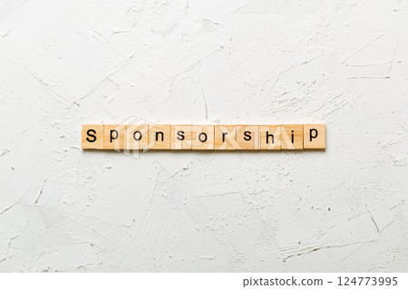 Sponsorship word written on wood block. Sponsorship text on table, concept 124773995