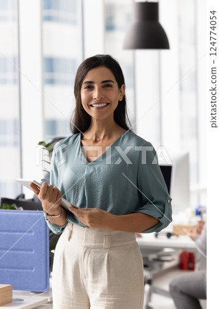 Positive confident Latin businesswoman posing in workspace 124774054