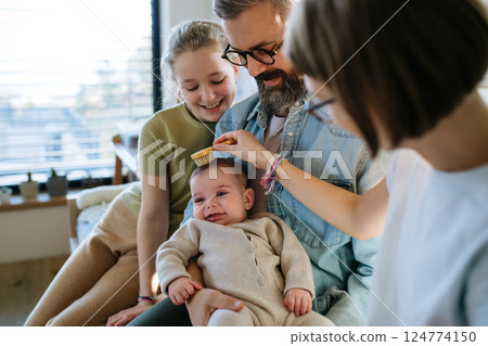 Older sisters helping with little baby brother. 124774150