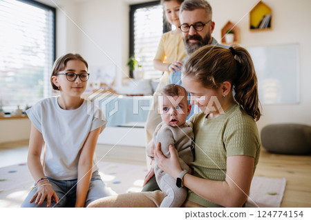 Older sisters helping with little baby brother. Older sisters helping with little baby brother. 124774154