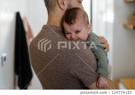 Father comforting his crying baby son. 124774185