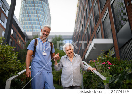 Caring healthcare worker helping elderly woman walk the stairs. Caring healthcare worker helping elderly woman walk the stairs. 124774189