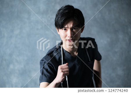 一位年輕的男醫生穿著手術服,表情嚴肅認真,一邊看著鏡頭,一邊朝著自己的目標或未來奔跑 一位年輕的男醫生穿著手術服,表情嚴肅認真,一邊看著鏡頭,一邊朝著自己的目標或未來奔跑 124774240