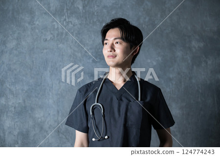 Image of a smiling young male doctor wearing a scrub Image of a smiling young male doctor wearing a scrub 124774243