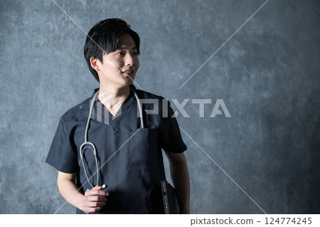 一位身穿手術服、微笑的年輕男醫師的照片 124774245