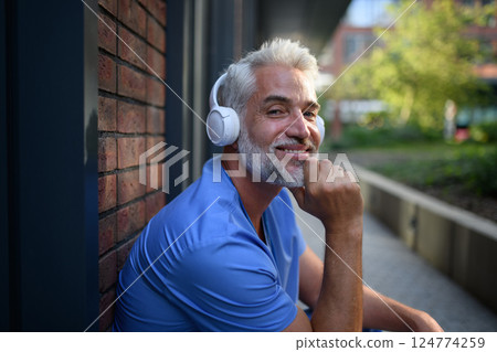 Healthcare worker relaxing with music outside hospital. 124774259