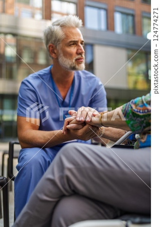 Close up of holding hands of healthcare worker and senior patient. 124774271