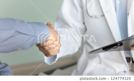 Doctor shaking hands with male patient, close up Doctor shaking hands with male patient, close up 124774320