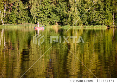Fishing in a Boat on Calm Forest Lake 124774374