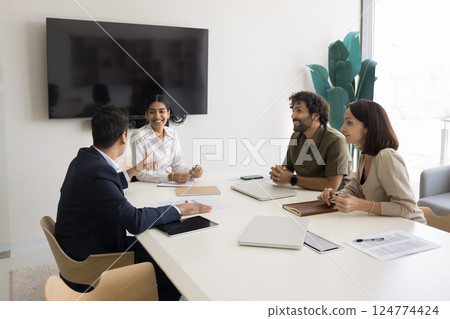 Positive teammates take part in briefing, laughing, enjoy pleasant conversation Positive teammates take part in briefing, laughing, enjoy pleasant conversation 124774424