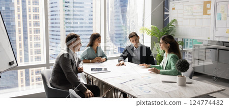 Business team talking at table, discussing job tasks Business team talking at table, discussing job tasks 124774482