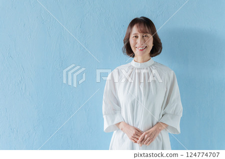 Smiling middle-aged woman (blue background) 124774707