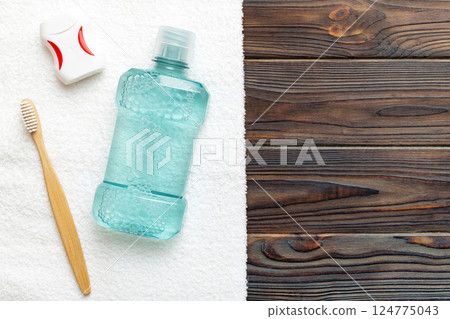 Mouthwash and other oral hygiene products on colored table top view with copy space. Flat lay. Dental hygiene. Oral care products and space for text on light background. concept Mouthwash and other oral hygiene products on colored table top view with copy space. Flat lay. Dental hygiene. Oral care products and space for text on light background. concept 124775043